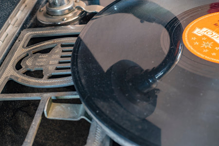 Berlin, Germany - April 1, 2019: Integrated horn of a historic record player (gramophone) from Germany in the in the 1920's with a shellac disc and the reflection of the pickup.のeditorial素材
