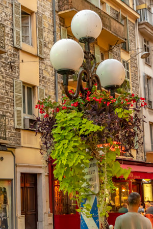 Nice, France - October 5, 2018: Scene on an evening with a nicely planted street lamp in a pedestrian street in Nice, France.のeditorial素材