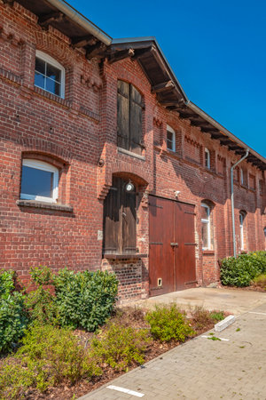 Detail view of an old farm. The facade is made of brick. In it are old wooden gates, which were used for loading and unloading of barn and storage.のeditorial素材