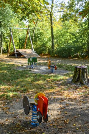 Children's playground in Germany with various rocking swings and a zip-line in the background.
