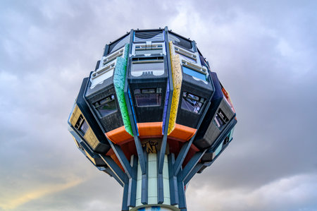 Berlin, Germany - October 5, 2019: Restaurant tower of the seventies from painted concrete in a business street in Berlin-Steglitz against rainy sky.のeditorial素材