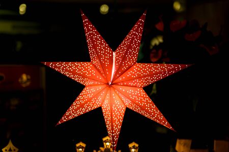 Evening shop window with a lit up Christmas star as decoration in a small shop on the island Usedom...