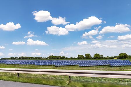 Solar system for sustainable energy generation on a meadow near a freeway in Germany under a sunny...