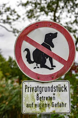 Information sign, dogs are not allowed to shit here, with the German label Private country, enter at...