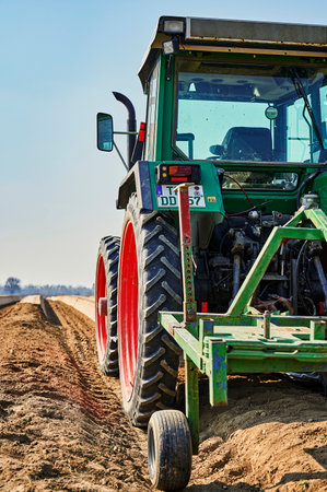 Brandenburg, Germany - March 28, 2020: You look past a tractor at an asparagus field in Germany. The...