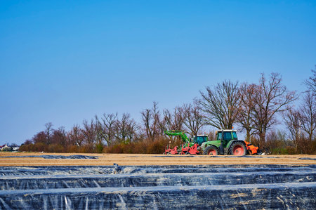 Brandenburg, Germany - March 28, 2020: View to tractors and machines that are ready to prepare an asparagus field in Germany for cultivation.のeditorial素材