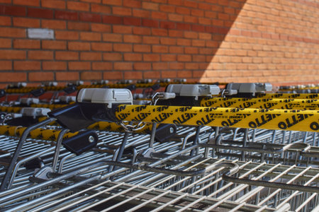 Berlin, Germany - April 02, 2018: A row of shopping trolleys with focus on the handles and locks...