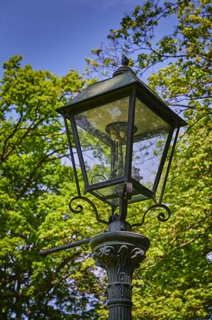 Historic and still functional street lamp that is powered by gas and stands in a Berlin park.の写真素材