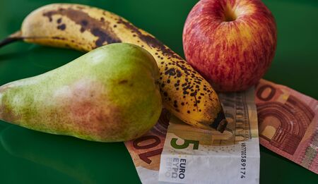 Fruit lying together with European banknotes on a green background.の写真素材