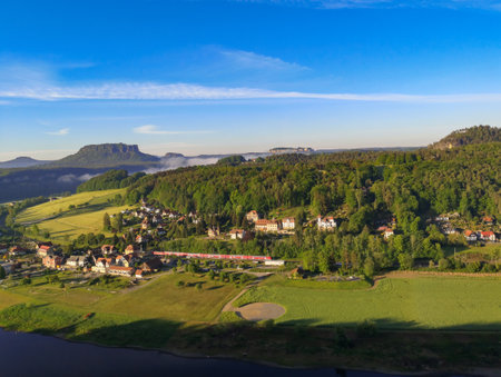 Rathen, Germany - May 21, 2020: View from the Bastei in Saxon Switzerland over the Elbe valley, in which you can see a town and a train that is just passing the valley.のeditorial素材