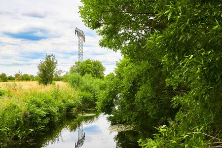 Cloudy sky over a little creek in the surrounding countryside of Berlin, Germany.の写真素材