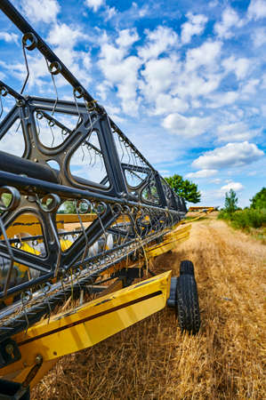 View along a mowing machine standing on a harvested field in the surrounding countryside of Berlin, Germany. The focus lies on the middle of the machine.の写真素材