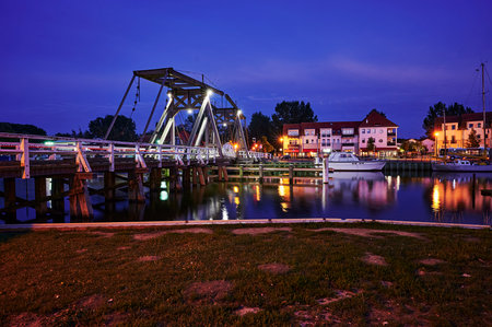 Greifswald, Germany - August 30, 2020: View of the Greifswald sailing harbor with the historic drawbridge and reflecting lights at the blue hour.のeditorial素材