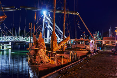 Greifswald, Germany - August 30, 2020: View of the Greifswald sailing harbor with the historic drawbridge and reflecting lights at the blue hour.のeditorial素材