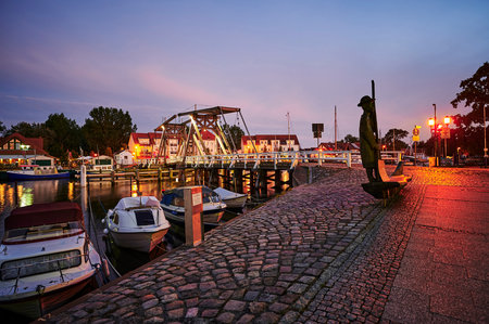 Greifswald, Germany - August 30, 2020: View of the Greifswald sailing harbor with the historic drawbridge and reflecting lights at the blue hour.のeditorial素材