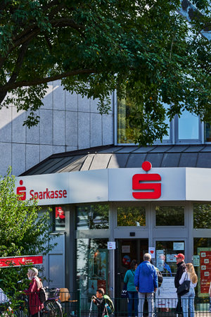 Berlin, Germany - September 17, 2020: Customers queuing in front of a bank branch, some of whom are wearing a face mask because of Covid-19.のeditorial素材