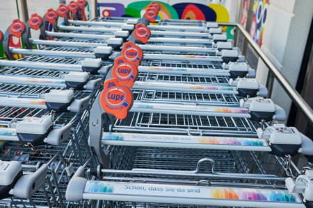 Berlin, Germany - October 3, 2020: View to a row of shopping carts in front of a shop. There is a magnifying glass on the car so that the visually impaired can read the prices better.のeditorial素材