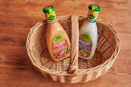 Berlin, Germany - November 20, 2020: Bottle with salad dressing and German lettering in a basket. The focus lies in the middle of the bottles.のeditorial素材