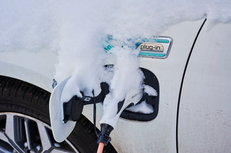 Berlin, Germany - February 10, 2021: View to a hybrid electric vehicle in winter with snow on the charging plug.のeditorial素材