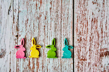 Four colorful Easter bunnies on a wooden table.