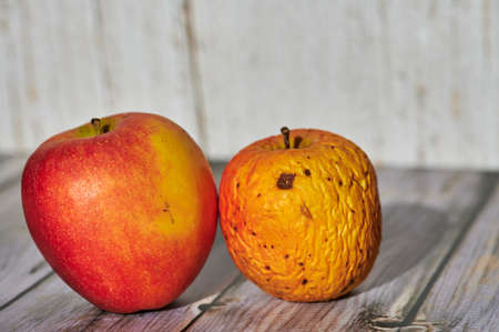 Apples lit from the sun decoratively lying on a wooden underground.