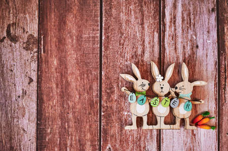 Wooden Easter bunnies with decoration and the text Easter written on eggs.の写真素材