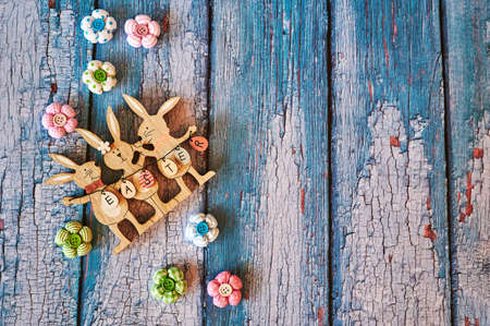 Wooden Easter bunnies with decoration and the text Easter written on eggs.