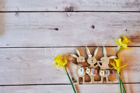 Wooden Easter bunnies with decoration and the text Easter written on eggs.の写真素材