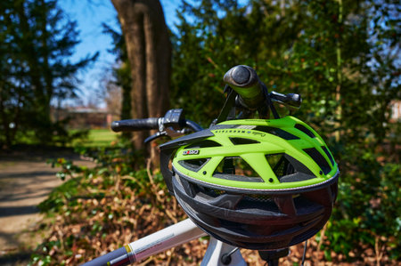 Berlin, Germany - March 31, 2021: View to a modern bicycle helmet that hangs on the handlebars of a bicycle.のeditorial素材