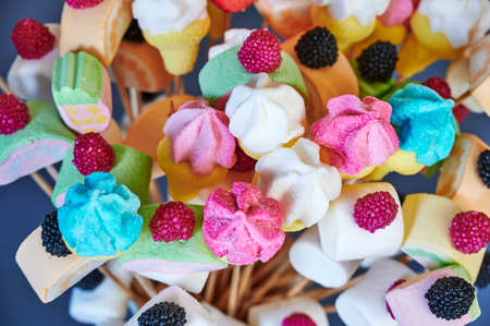Sweets made from marshmallows and other delicacies on wooden skewers arranged like a bouquet of...