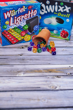 Berlin, Germany - July 14, 2021: Dice cup, dices and different packs of games as activity against boredom.のeditorial素材
