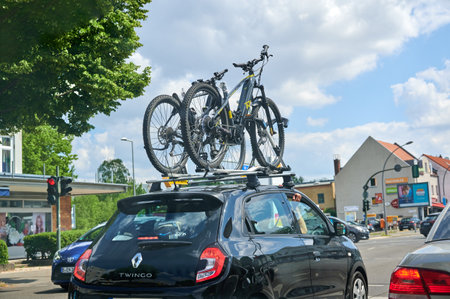 Berlin, Germany - July 3, 2021: Car with a bike carrier attached on the top and two bicycles mounted on it.のeditorial素材