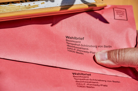 Berlin, Germany - September 09, 2021: An election letter being thrown into the mail slot of a mailbox for the federal election in Germany.のeditorial素材
