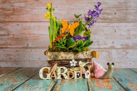 Pretty arrangement of different spring flowers with decoration on a wooden table.