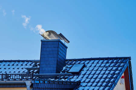 View of a roof with a chimney against a blue sky.の写真素材