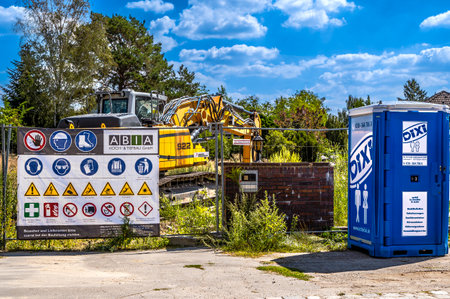 Berlin, Germany - August 11, 2022: View to a jobsite with warning signs, digger and makeshift...