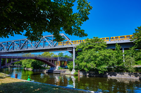 Berlin, Germany - July 17, 2022: View to a metro train operated by Berliner Verkehrsbetriebe (BVG) on a historic bridge on an overhead railway line.のeditorial素材