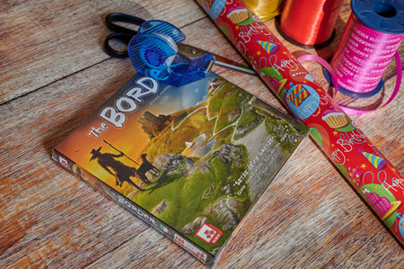 Berlin, Germany - September 25, 2022: Board game with wrapping paper, scissors and ribbon for wrapping.のeditorial素材