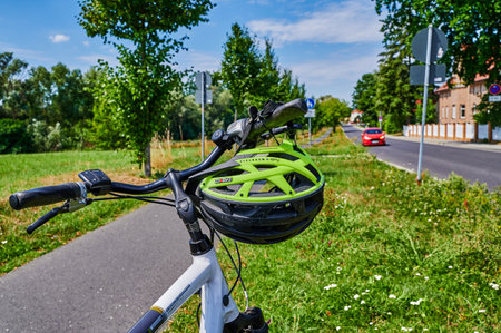 Berlin, Germany - July 29, 2022: View to a modern bicycle helmet that hangs on the handlebars of a bicycle.のeditorial素材
