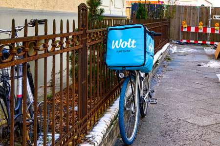 Berlin, Germany - February 9, 2023: Bike of a food delivery service parked on a sidewalk.のeditorial素材