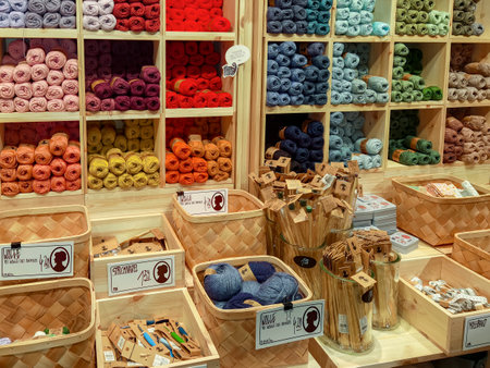 Berlin, Germany - March 28, 2023: A shelf full of colorful balls of yarn in a shop with various accessories in the foreground.のeditorial素材