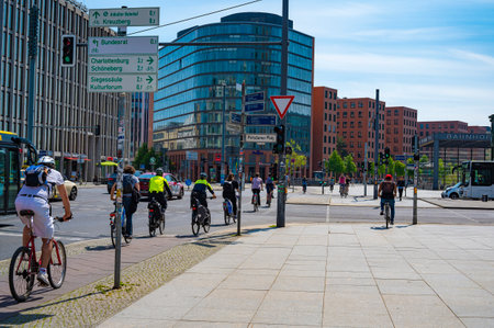 Berlin, Germany - May 8, 2020: Bicycle traffic at Potsdamer Platz in downtown Berlin. At the traffic light, two police officers from the bicycle squadron are driving off.のeditorial素材