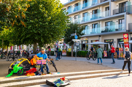 Bansin, Germany - September 12, 2019: City life with a street musician in the pedestrian zone of the Kaiserbad Bansin on the island of Usedom.のeditorial素材