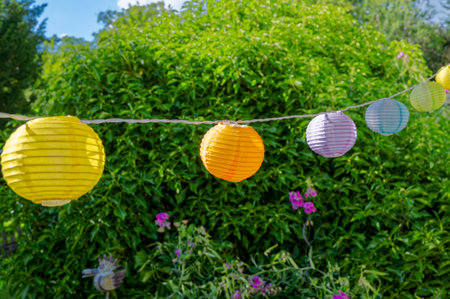 Summerly garden scene with colorful lanterns hanging in a row.の写真素材