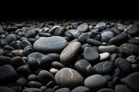 black and white pebbles on the beach with dark background.の素材