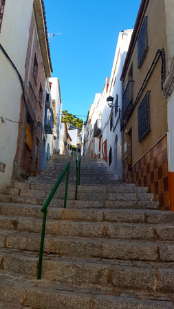 Stone stairs in a street with houses either side and green metal railings.の写真素材