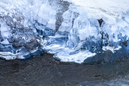 Edge of ice surface of almost frozen river. Toned.