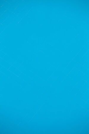 View through the pool water to the bottom of the blue tiles. A fragment of the pool as a background.の写真素材