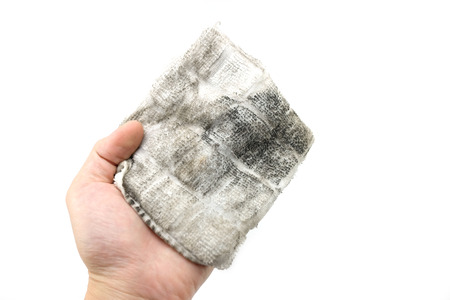 Black dust on the towel isolated on white background. Wipe dirty surface by hand with white towel.の写真素材