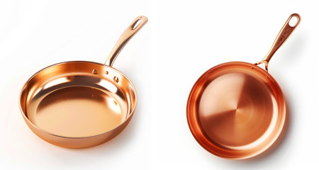Two new shiny copper pans with a reflective surface isolated on a white background, representing high-end cookware.の素材